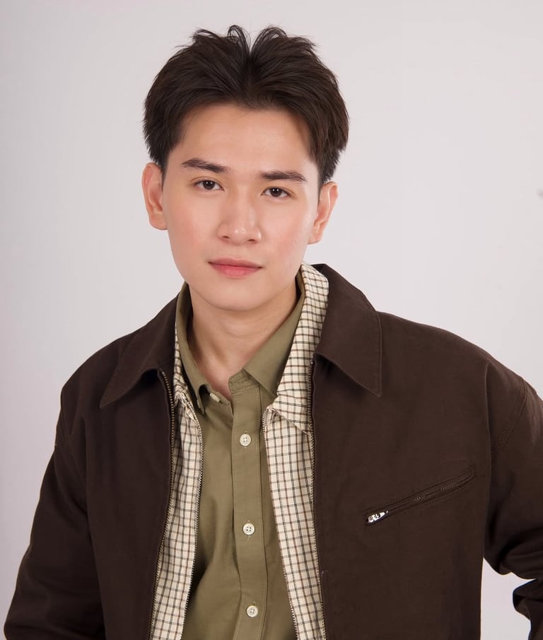 Young man wearing a brown jacket over a checkered shirt against a plain white background