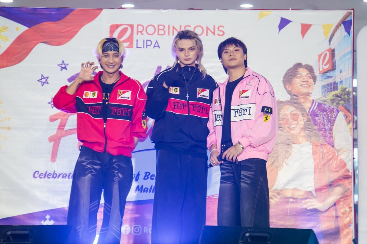 Four people on stage wearing branded jackets at Robinson Lipa event with colorful backdrop and promotional signage