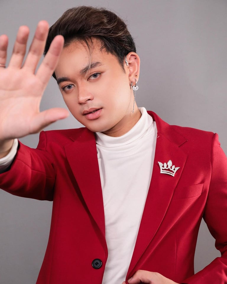 Person in red blazer and white shirt raising hand in stop gesture against gray background