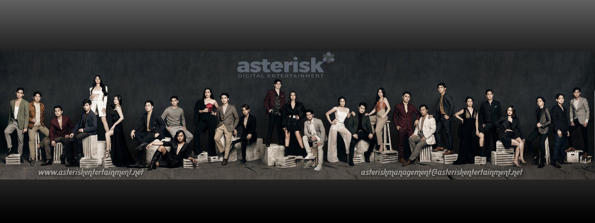 Large group of people in professional attire standing together against dark background with Asterisk logo