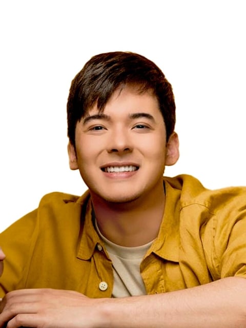 Young Asian man smiling and wearing a yellow button-up shirt over a light colored shirt