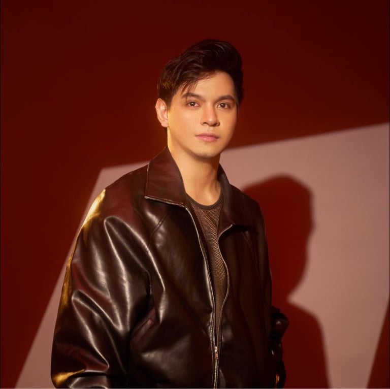 Young man in black leather jacket against red background with dramatic lighting